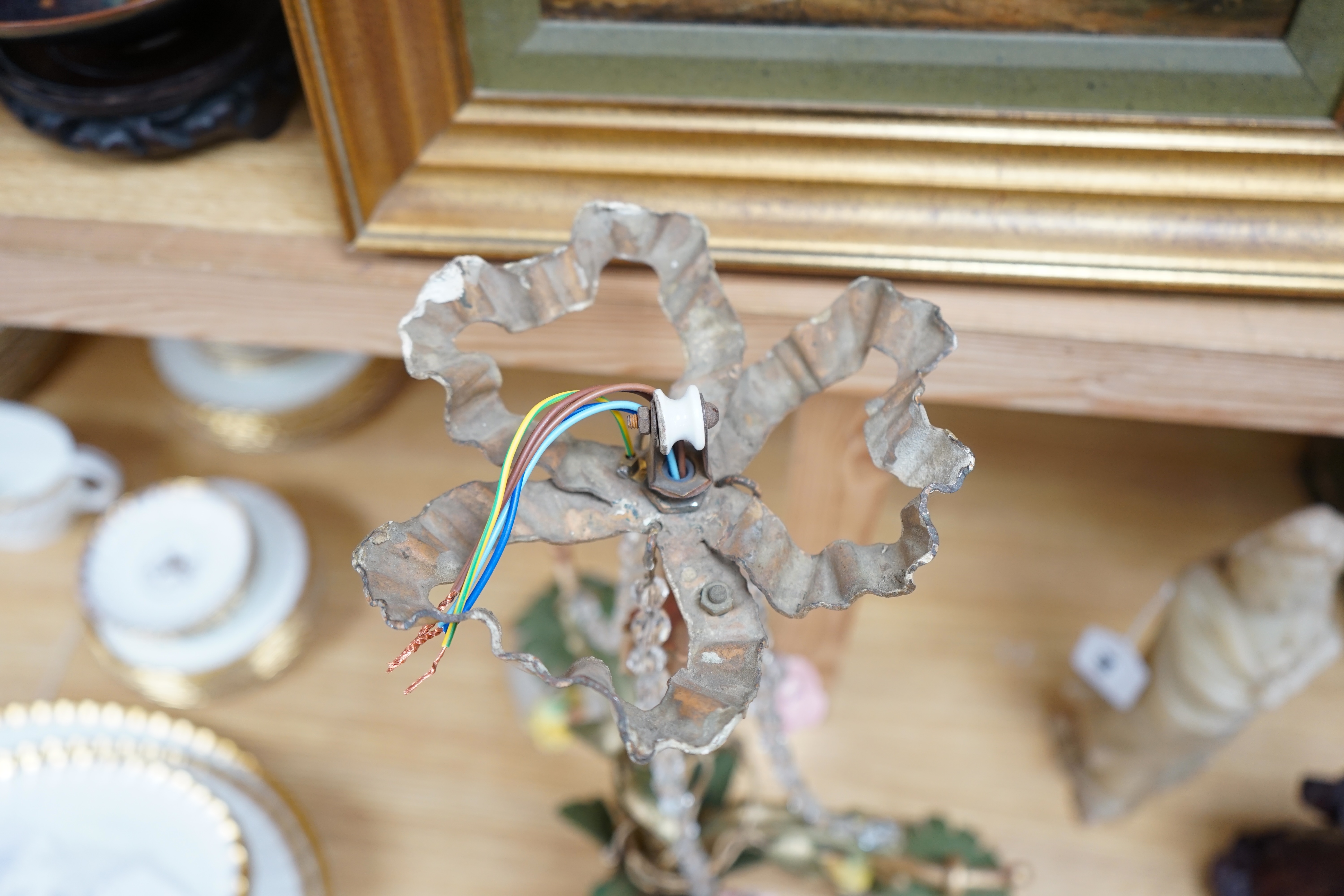 A French three arm coloured wrought iron ceiling light with frosted petal shades and porcelain flower decoration, circa 1930’s, 57cm high, 36cm across. Condition - fair